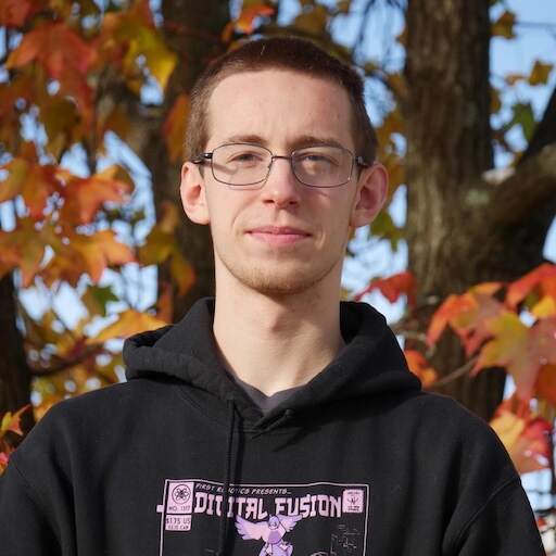 kieran wearing a robotics sweatshirt and standing in front of a tree with fall leaves